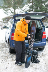 Preparing for an adventurous day of snowboarding in a snowy mountain landscape while enjoying the...