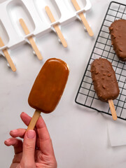  Top View of Caramel Ice Cream Bar in Woman’s Hand