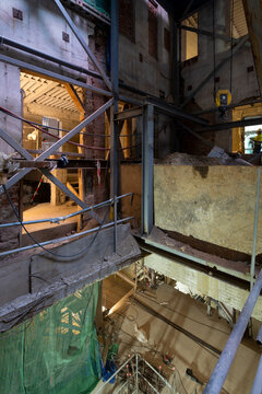 Construction site interior with exposed beams and workers
