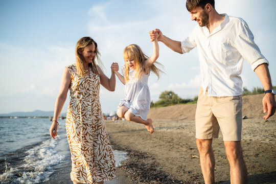 Parents playing with their child on an Italian beach