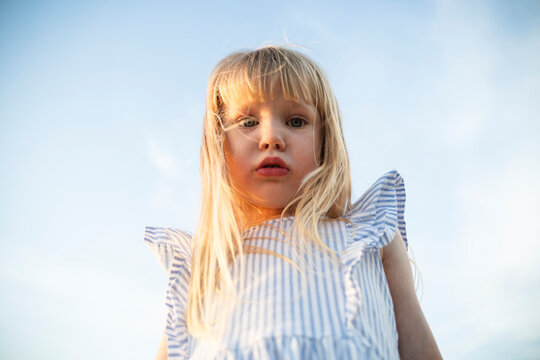 Portrait of a young girl under the summer sky in Italy