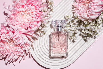 Elegant perfume bottle surrounded by pink and white flowers