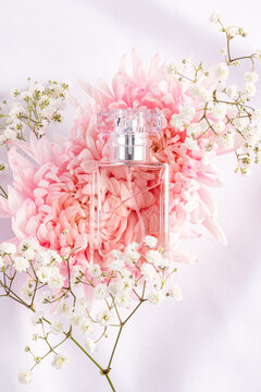 Elegant glass perfume bottle surrounded by pink and white flowers