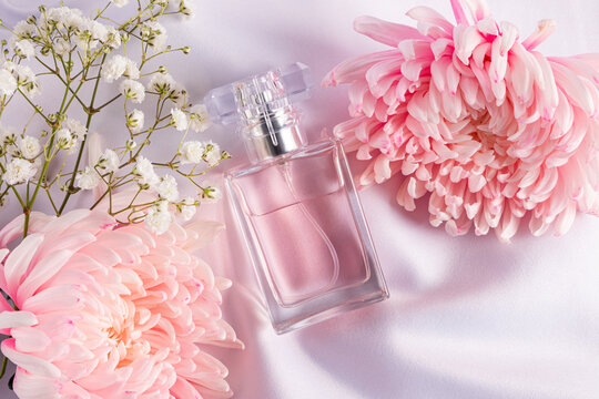 Elegant composition of pink perfume bottle and flowers