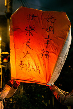 Brightly lit Chinese floating lantern with messages being released