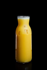 Fresh Orange juicy in a glass bottle on a black background
