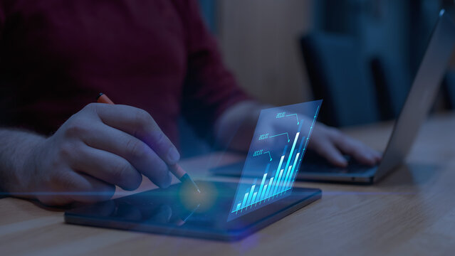 Businessman analyzing futuristic bar chart data. Concept of market growth, financial analytics, and digital economy.