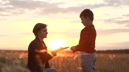 Son extends hand to mother sharing hug in field. Son and mother embrace warmly. Son with mother continue to walk in nature maintaining loving with supportive connection through heartfelt hugs