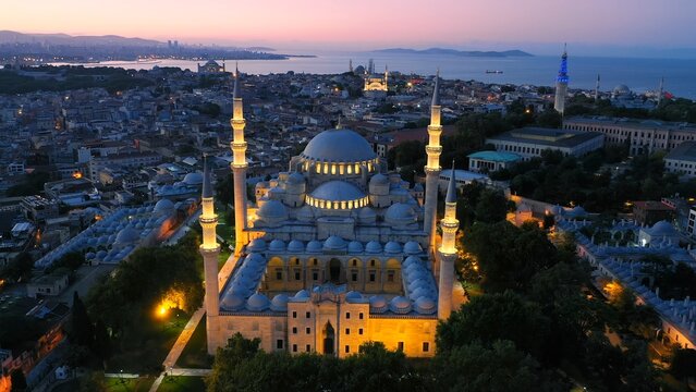 Aerial view of Istanbul at dawn with the illuminated S&uuml;leymaniye Mosque, Marmara Sea, Hagia Sophia, Blue Mosque, and Beyazit Tower in the background