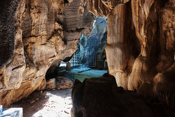 Exploring the intricate rock formations in a captivating cave at midday revealing hidden treasures