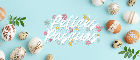 Frame made of decorated Easter eggs and leaves on blue background