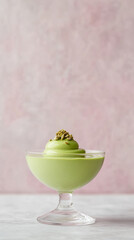Elegant vertical banner featuring avocado mousse dessert in glass with pistachio garnish