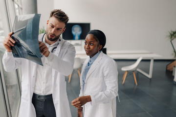 Fototapeta premium Doctors examining x ray of patient in modern hospital