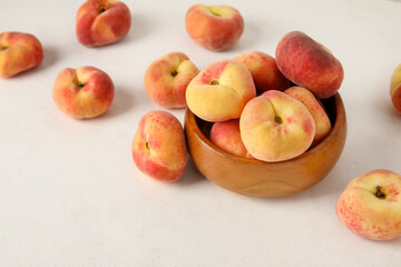 Wooden bowl with sweet fig peaches on white background