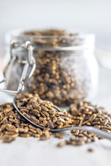 Milk thistle seeds in spoon on kitchen table.