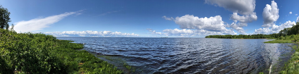 large panorama lake shore, green shores blue sky picturesque summer landscape