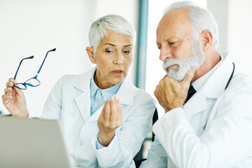 Fototapeta premium doctor senior elderly woman man hospital team medical laptop computer health medicine healthcare meeting teamwork professional clinic office nurse