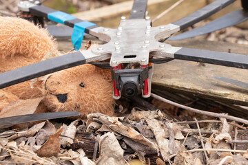 A downed Russian FPV drone lies in the ruins of a destroyed abandoned house next to a child's brown...