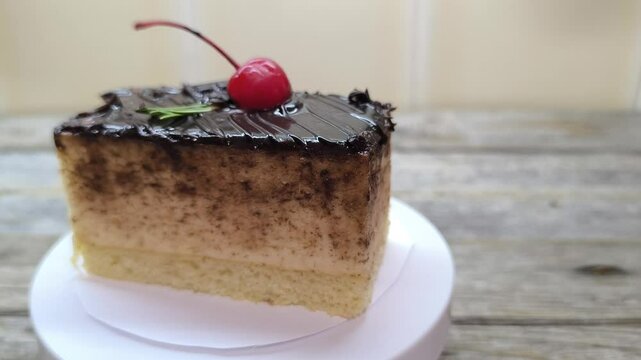 Chocolate cake with cherries lies on a white plate