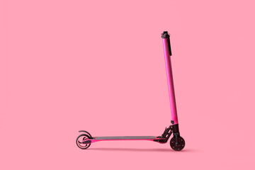Pink modern electric kick scooter on color background