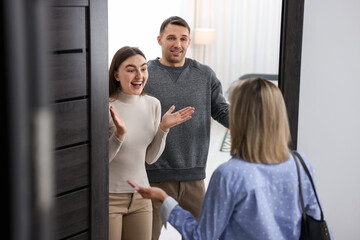 Lovely couple welcoming friend to their apartment