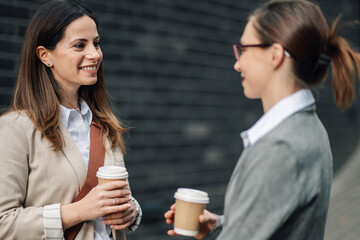 Businesswomen talking and drinking coffee during a break outside the office