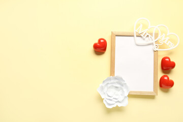 Composition with blank frame and hearts for Valentine's Day on beige background