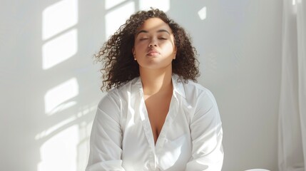 A plus-size woman sitting gracefully in a bright, airy space, radiating self-acceptance and beauty.