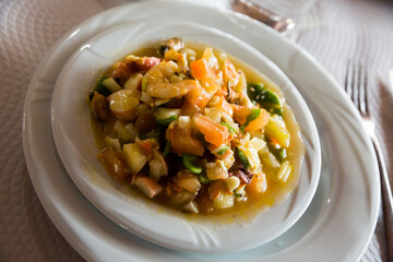 Shellfish cocktail with vegetable mix (seafood salpicon) traditionally served cold on white plate