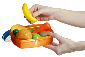 Hand holding collection of plastic food inside an orange container lunch box on white background...