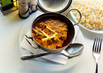 Traditional Indian lamb karahi curry served with ginger and white rice. National cuisine dish