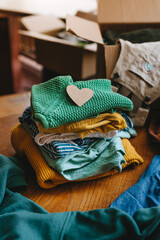 Close-up of paper heart near an old out-of-use kid clothes for charity or upcycling