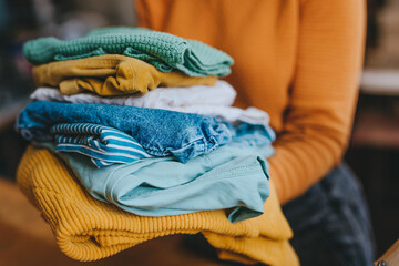 Close-up of female volunteer holding clothes collected for charity or converting discarded materials