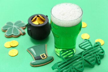 Glass of beer with decorative glasses, coins and sweet cookies on green background. St. Patrick's...