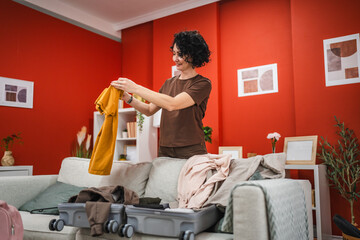 mature woman stand and pack suitcase baggage prepare for vacation
