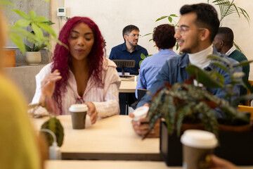 Fototapeta premium Diverse business team collaborating in modern coworking space with plants