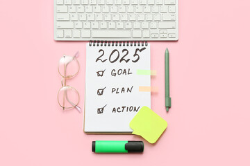 Notebook with to do list, sticky notes and computer keyboard on pink background. New year goals...