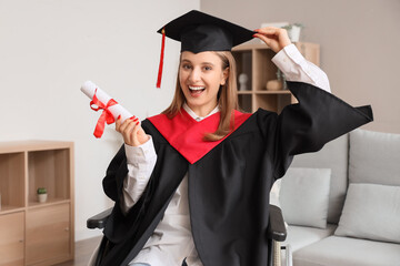 Female graduate in wheelchair with diploma at home