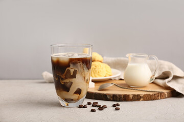 Glass of iced latte and coffee beans on white background