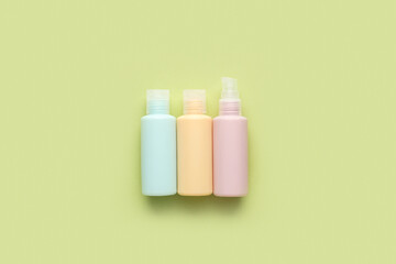 Set of travel cosmetic bottles on color background