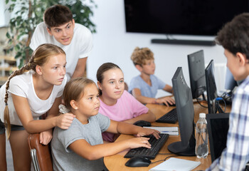 Obraz premium Group of children students learn to work with computer at lesson
