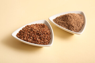 Bowls of flax seeds and flour on beige background