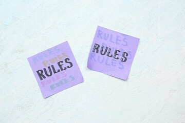 Sticky notes with word RULES on white grunge background