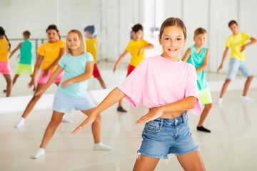 Fototapeta premium Group of kids training modern dance moves together in studio.