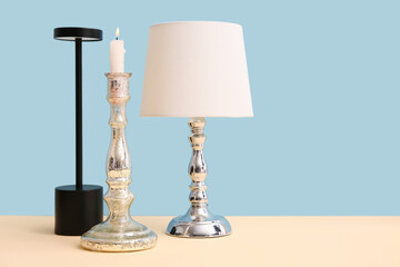 Lamps and candle on table against blue background. Concept of evolution