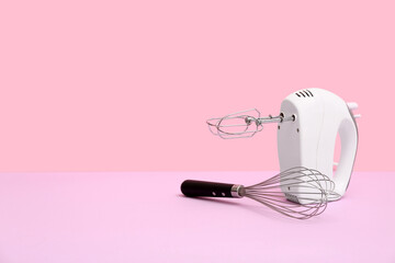 Modern mixer with whisk on pink background. Concept of evolution