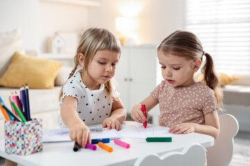 Fototapeta premium Cute little sisters drawing at white table in room