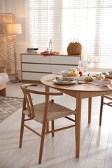 Stylish table setting with beautiful dishware and autumn decor in dining room