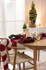 Christmas table setting with stylish dishware and festive decor indoors