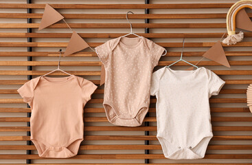 Baby bodysuits with flags hanging on wooden lattice